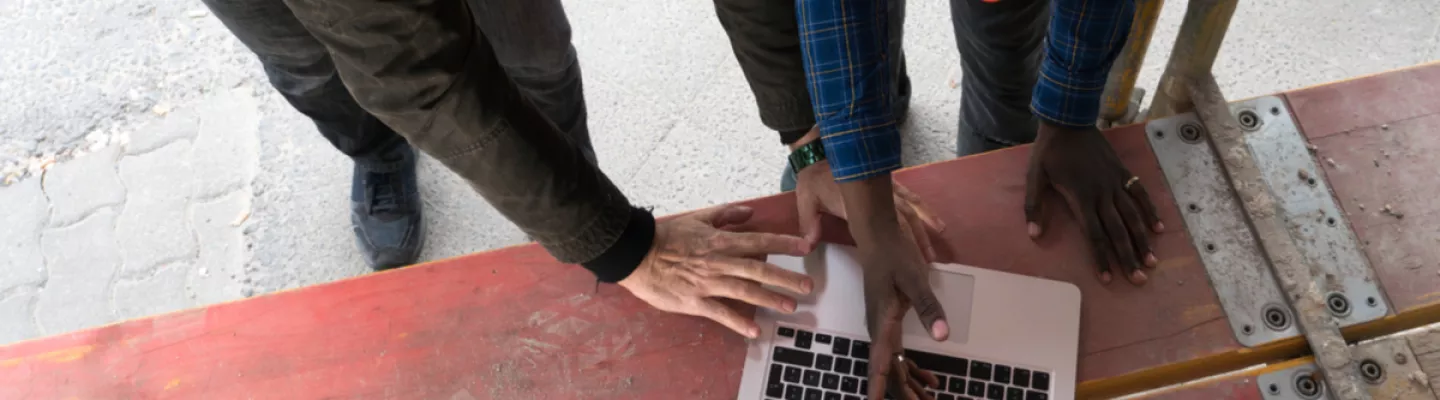 two civil engineers on construction site looking at laptop