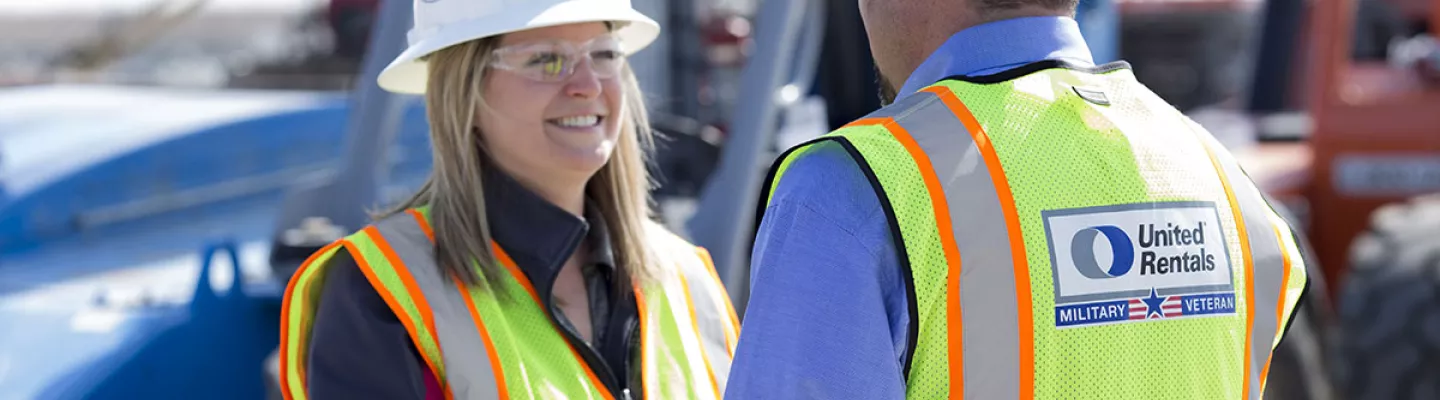 man shaking womans hand, both wearing PPE next to truck