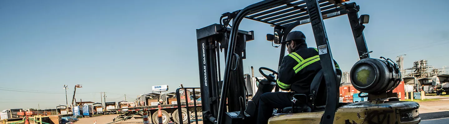 Worker using a forklift at job site