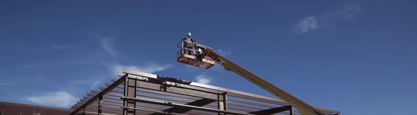 Workers using lifts at a job site