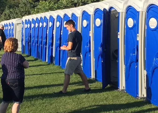 man walking out of porta potty