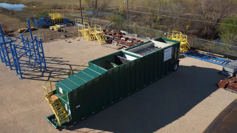 green tank at a jobsite on a sunny day
