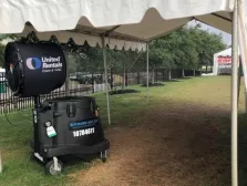 Black United Rentals Faan under a tent outside on grass