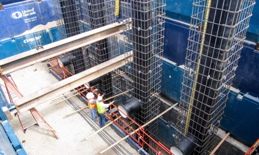 birdseye view of a trench jobsite with workers standing on composite matting