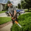 Orange Stihl hedge trimmer with 30 inch blade being used to cut hedges