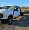 Angled front-right view of a white Ford F-350 Super Duty dually pickup truck with a flatbed.