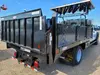 View from the right rear of a black truck with a box body and dual rear wheels.