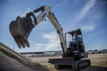 mini excavator on jobsite with extended bucket