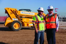 two men on jobsite next to forklift