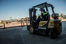 Worker using a forklift at job site